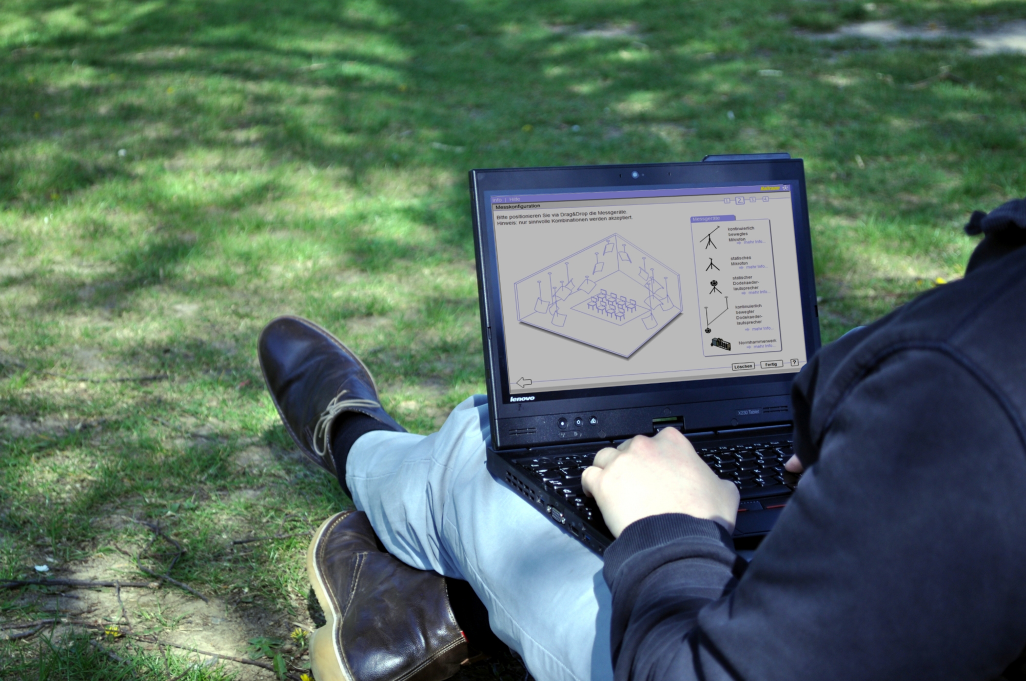 Person mit Laptop auf der Wiese